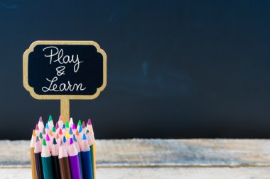 Wooden mini blackboard label with message Play and Learn