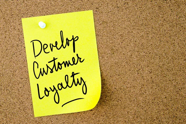 Develop Customer Loyalty text written on yellow paper note — Stock Photo, Image