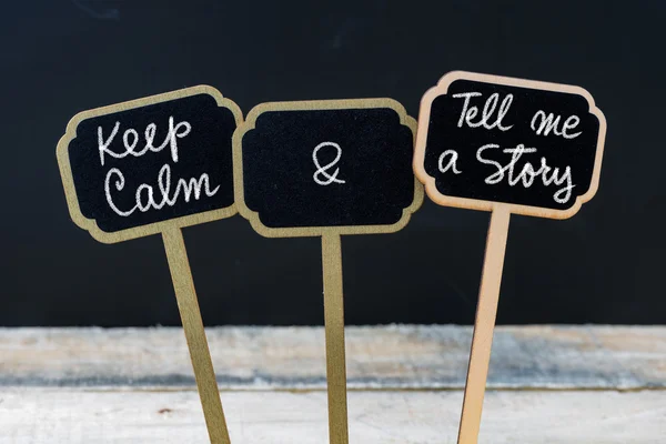 Keep Calm and Tell Me A Story message written with chalk on mini board labels — стоковое фото
