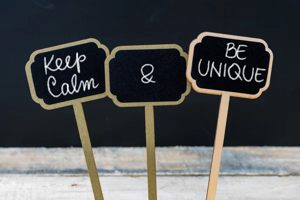 Keep Calm and Be Unique message written with chalk on mini blackboard labels — Stock Photo, Image