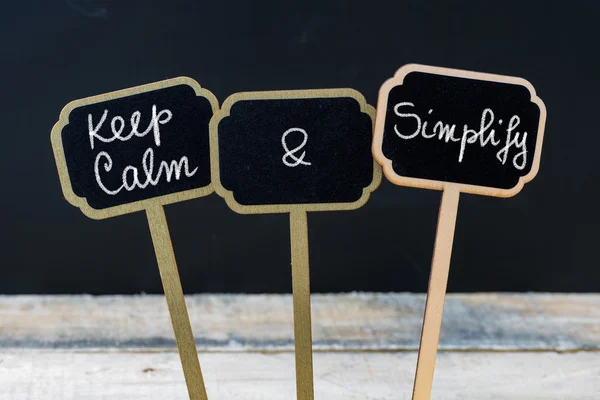 Keep Calm and Simplify message written with chalk on mini blackboard labels — Stock Photo, Image