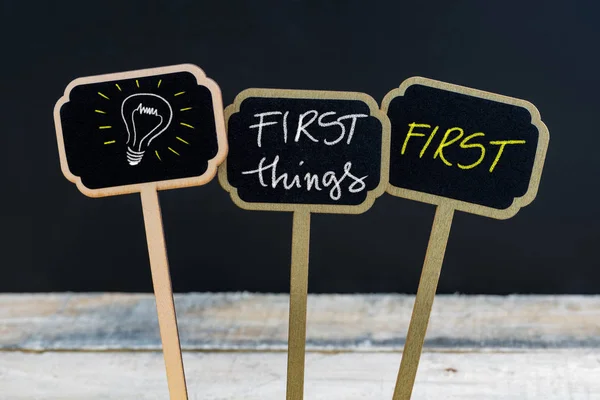 Concept message FIRST THINGS FIRST and light bulb as symbol for idea — Stock Photo, Image