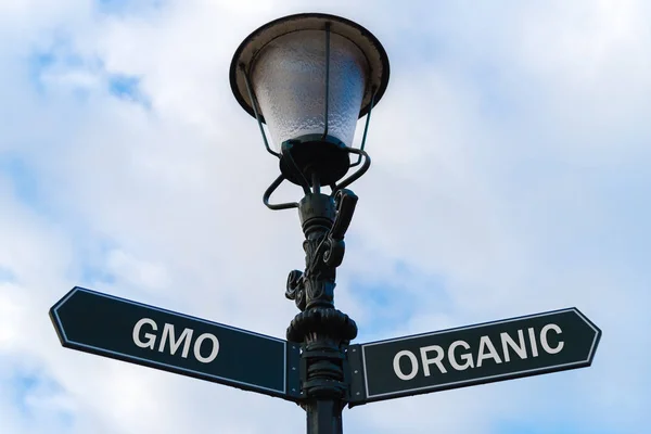 GMO versus Organic directional signs on guidepost — Stock Photo, Image