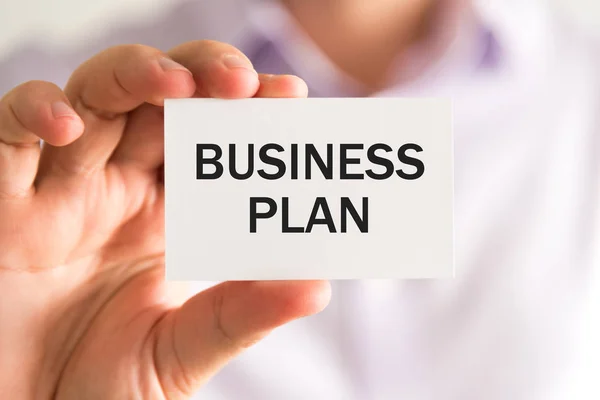 Empresário segurando um cartão com texto Plano de Negócios — Fotografia de Stock