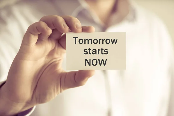 Businessman holding TOMORROW STARTS NOW message card — Stock Photo, Image