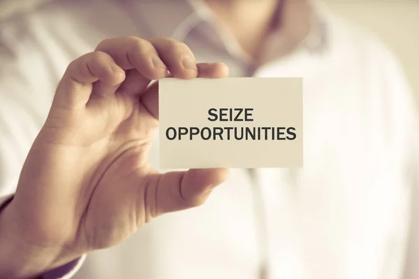 Uomo d'affari che detiene SEIZE OPPORTUNITIES message card — Foto Stock