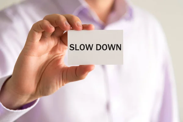 Affärsman som håller kortet med texten Slow Down — Stockfoto