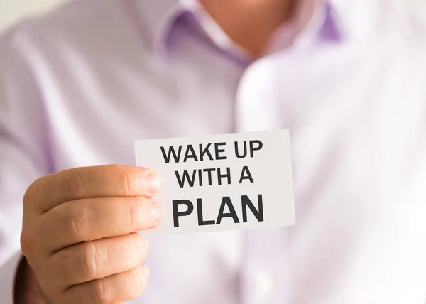 Affärsman som håller ett kort med texten vakna upp med en Plan — Stockfoto