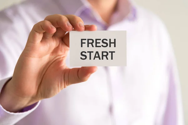 Empresário segurando um cartão com texto FRESH START — Fotografia de Stock