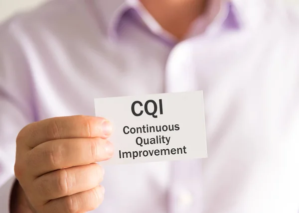 Zakenman met een kaart met tekst Cqi continue kwaliteitsverbetering — Stockfoto