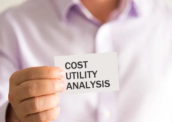 Podnikatel, drží kartu s textem Utility analýza nákladů — Stock fotografie