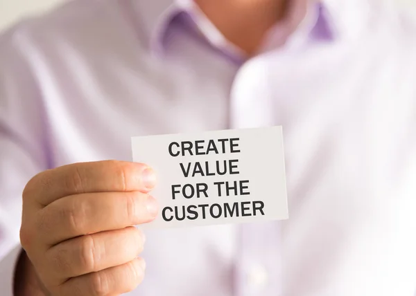 Affärsman som håller ett kort med texten skapa värde för kunden — Stockfoto