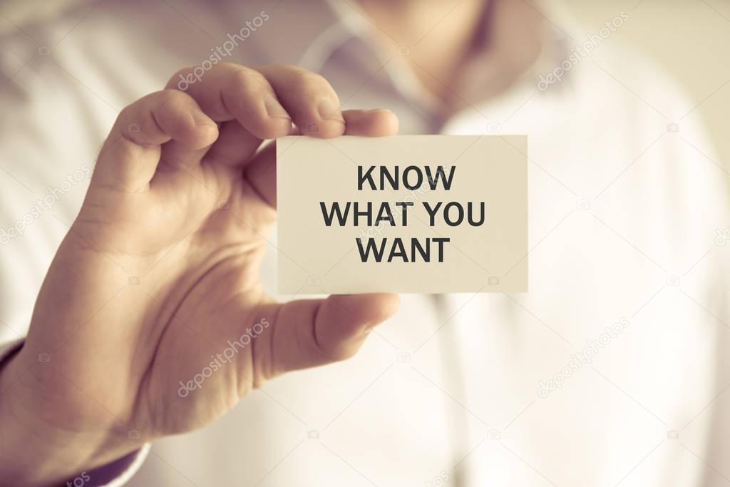 Businessman holding KNOW WHAT YOU WANT message card