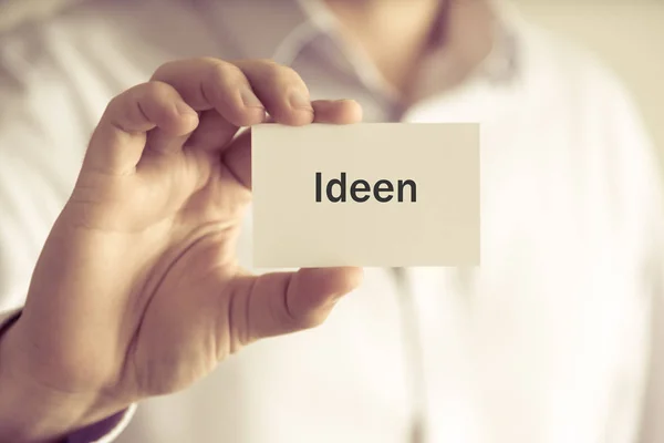 Empresário segurando cartão de mensagem "IDEEN" escrito em alemão - tradução: IDEA — Fotografia de Stock