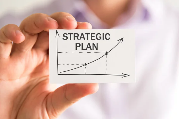 Geschäftsmann, der eine Karte mit strategischem Plan in der Hand hält — Stockfoto