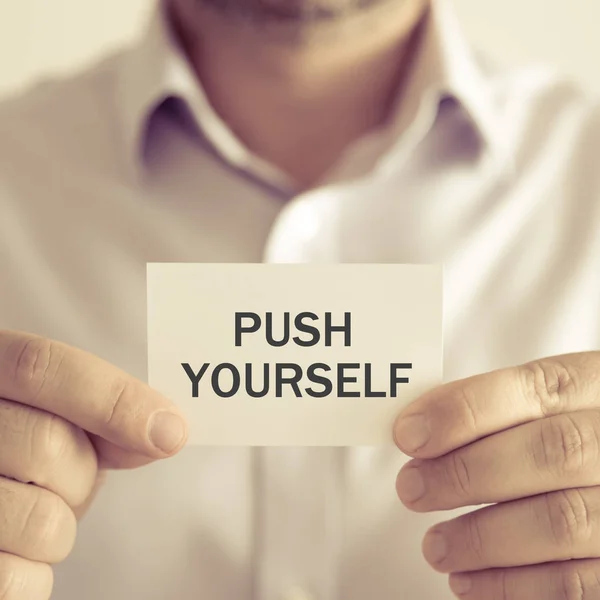 Businessman holding PUSH YOURSELF message card — Stock Photo, Image