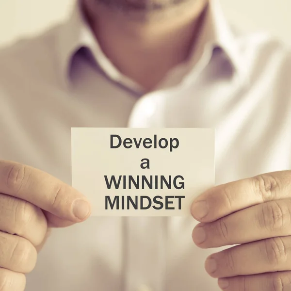 Businessman holding DEVELOP A WINNING MINDSET message card — Stock Photo, Image