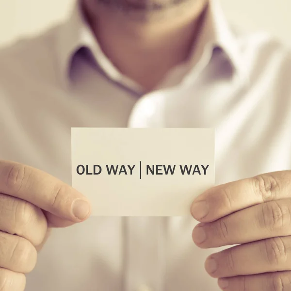 Geschäftsmann hält alte Weise neuen Weg Nachrichtenkarte — Stockfoto