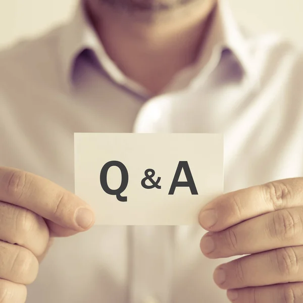 Businessman holding Q & A message card — Stock Photo, Image