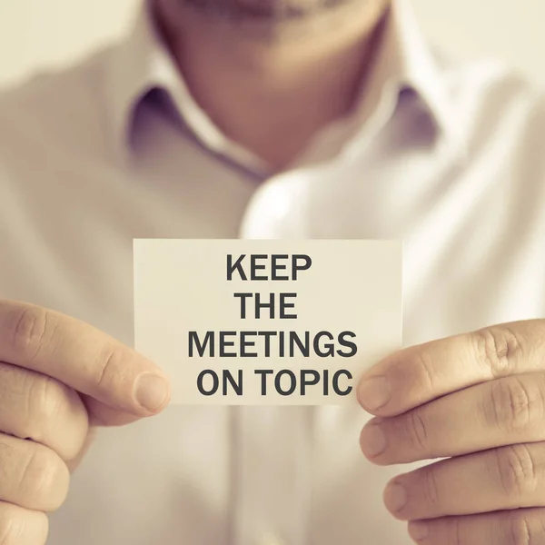 Businessman holding KEEP THE MEETINGS ON TOPIC message card — Stock Photo, Image