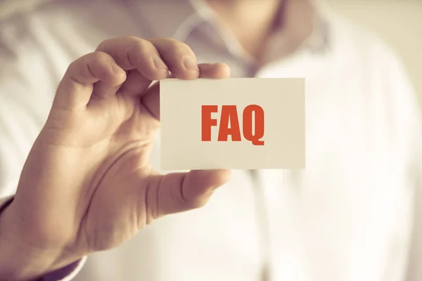 FAQ செய்தி அட்டையை வைத்திருக்கும் தொழிலதிபர் — ஸ்டாக் புகைப்படம்