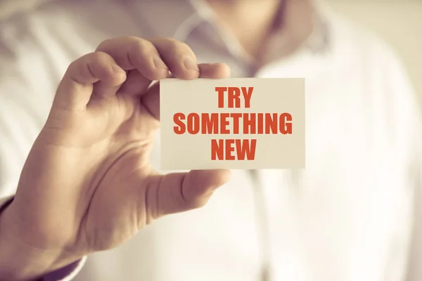 Businessman holding TRY SOMETHING NEW message card — Stock Photo, Image