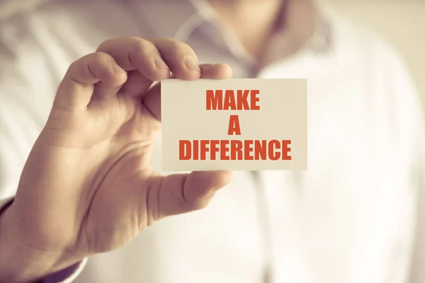 Businessman holding MAKE A DIFFERENCE message card — Stock Photo, Image