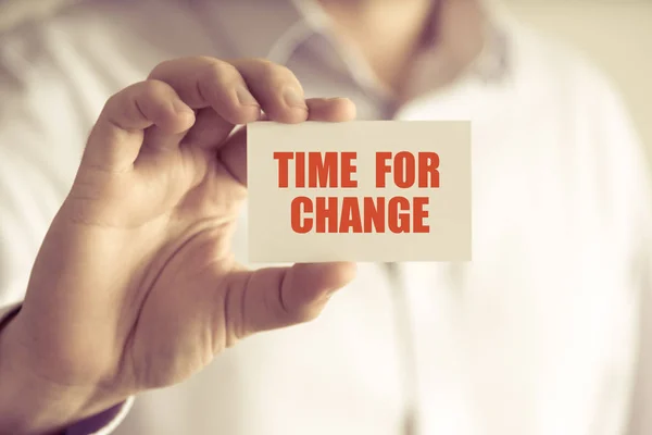 Бизнесмен держит карточку TIME FOR CHANGE — стоковое фото