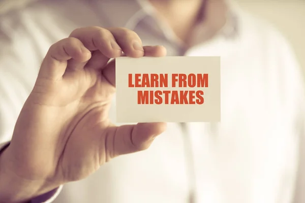 Businessman holding LEARN FROM MISTAKES message card — Stock Photo, Image
