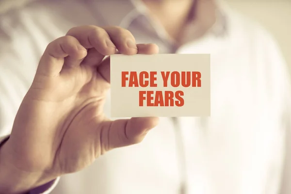 Businessman holding FACE YOUR FEARS message card — Stock Photo, Image