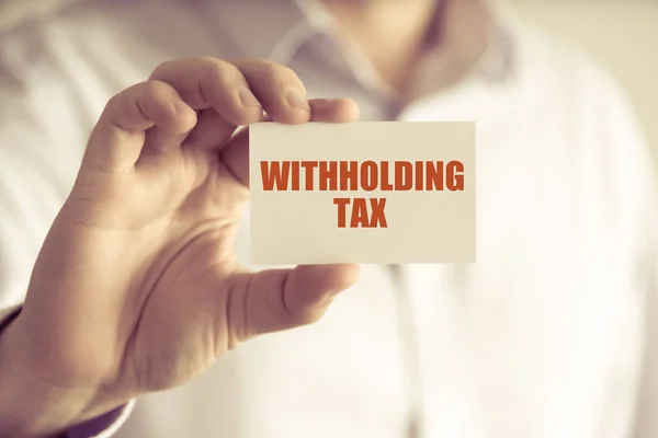 Businessman holding WITHHOLDING TAX message card