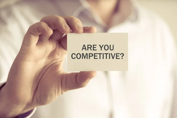 Empresário segurando você é competitivo? cartão de mensagem — Fotografia de Stock
