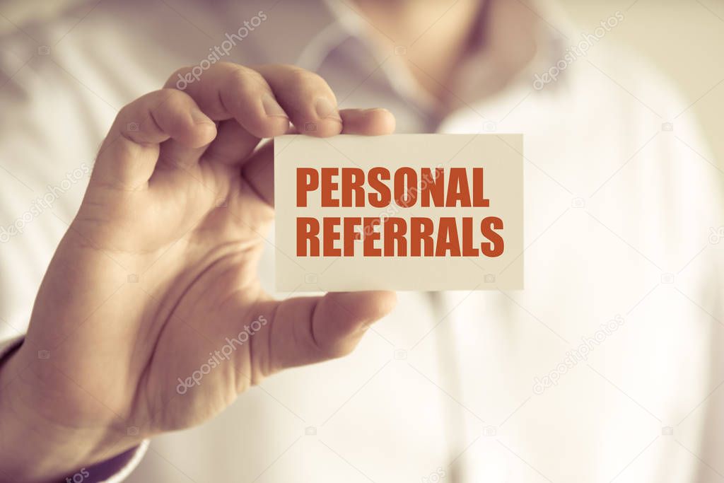 Businessman holding PERSONAL REFERRALS message card