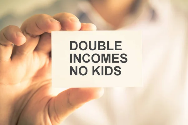 Businessman holding DOUBLE INCOMES NO KIDS message card — Stock Photo, Image