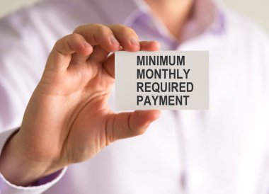 Mmrp Minimum aylık ödeme gerekli mesajı ile bir kart tutan işadamı
