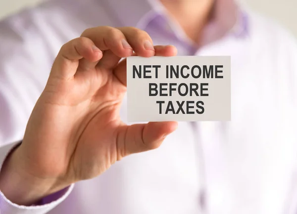 Empresário segurando um cartão com NIBT NET INCOME ANTES DA mensagem TAXES — Fotografia de Stock