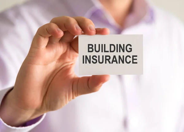 Businessman holding a card with BUILDING INSURANCE message — Stock Photo, Image