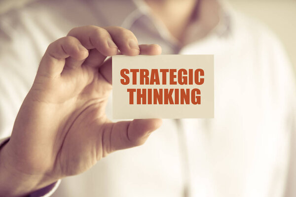 Бизнесмен с картой STRATEGIC THINKING
