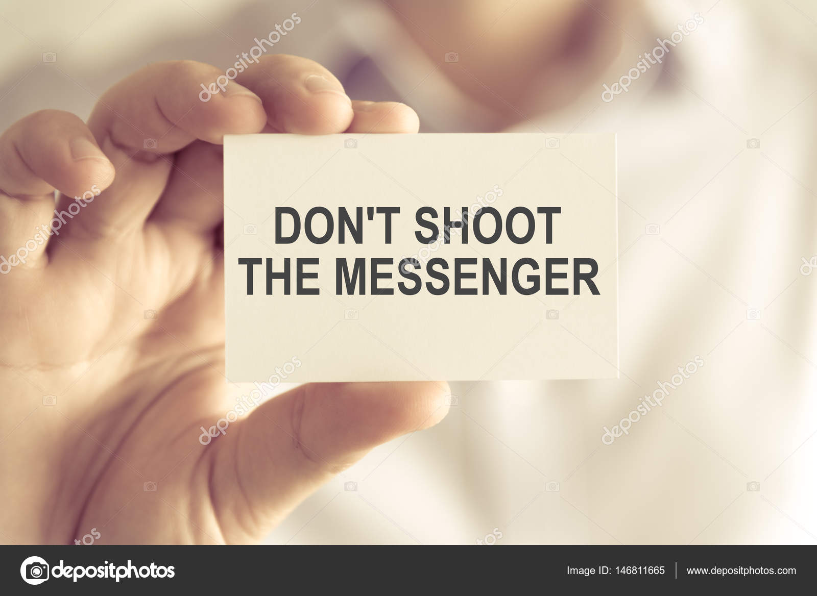 Businessman holding DONT SHOOT THE MESSENGER message card — Stock Photo
