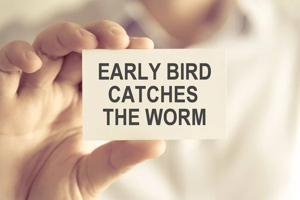 นักธุรกิจถือ EARLY BIRD CATCHES การ์ดจดหมายทํางาน — ภาพถ่ายสต็อก