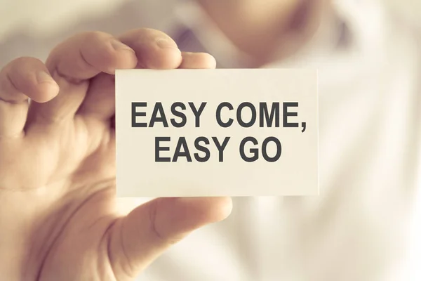 Empresário segurando EASY COME, EASY GO cartão de mensagem — Fotografia de Stock
