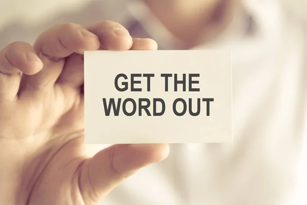 Businessman holding GET THE WORD OUT message card — Stock Photo, Image
