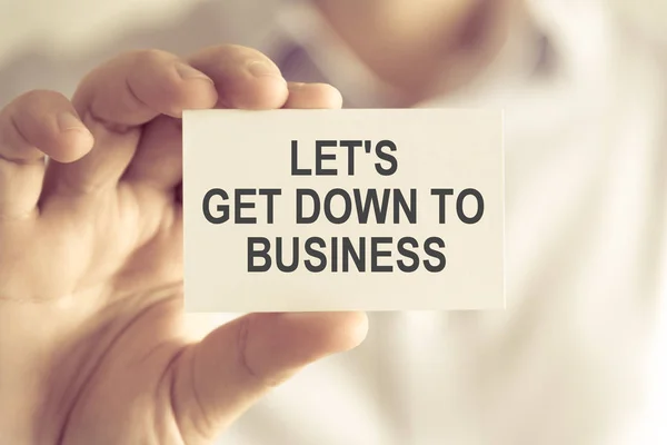 Uomo d'affari in possesso di LETS get down to business message card — Foto Stock