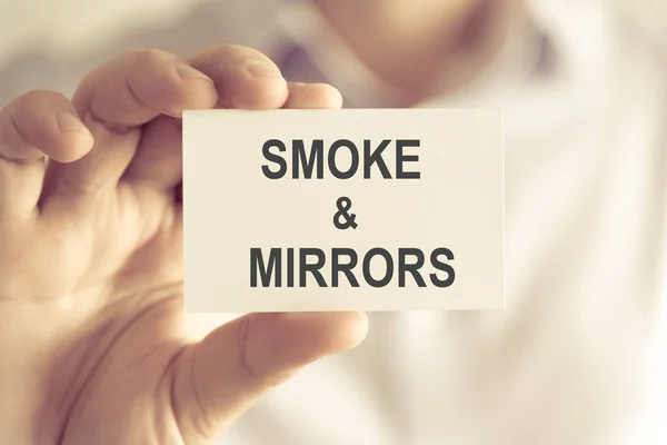 Biznesmen posiadania karty wiadomość dym i lustra — Zdjęcie stockowe