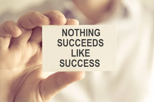 Businessman holding NOTHING SUCCEEDS LIKE SUCCESS message card — Stock Photo, Image