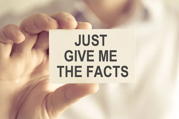 Businessman holding JUST GIVE ME THE FACTS message card — Stock Photo, Image