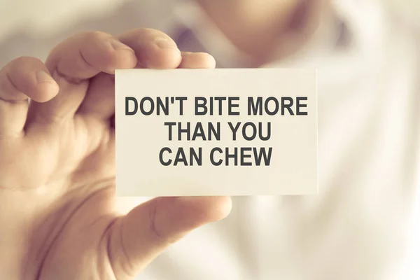 Empresário segurando DONT BITE MORE THAN YOU CAN CHEW message card — Fotografia de Stock