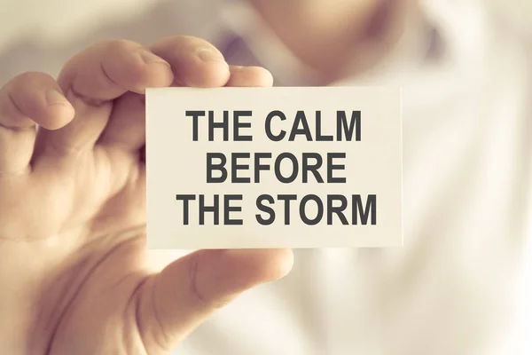 Businessman holding THE CALM BEFORE THE STORM message card — Stock Photo, Image