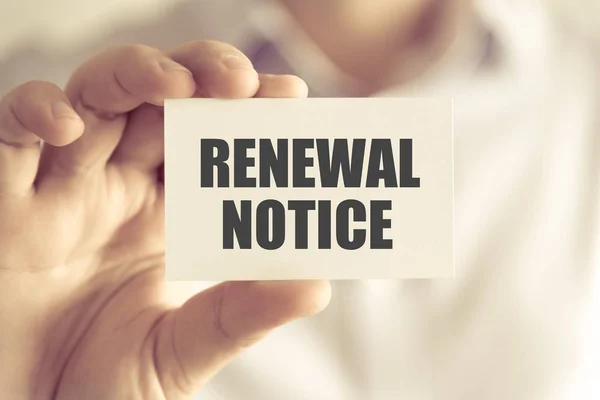 Бизнесмен, держащий в руках карточку RENEWAL NOTICE — стоковое фото