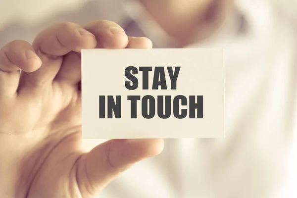 Businessman holding STAY IN TOUCH message card